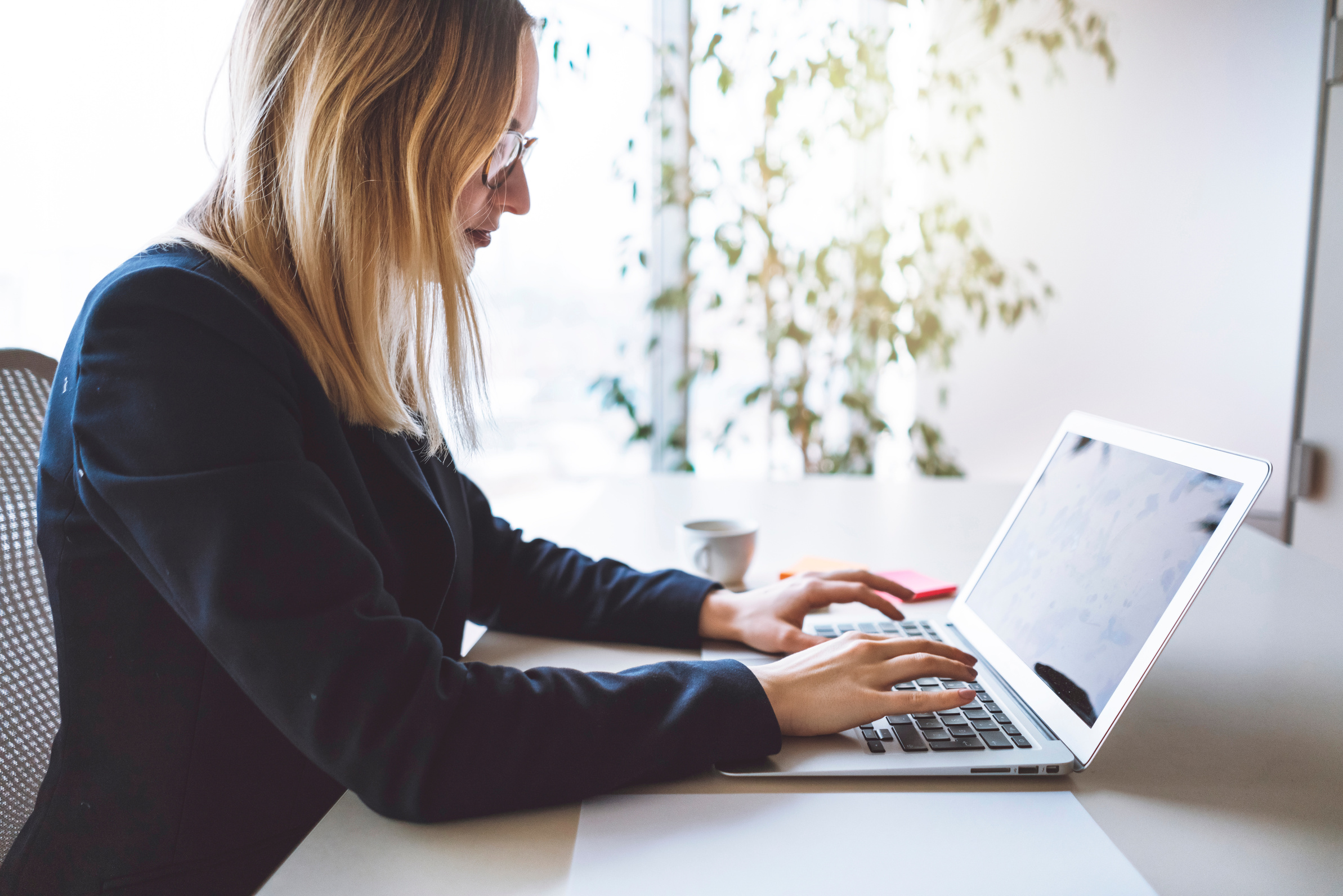 Blonde businesswoman writing e-mails